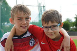 Zwei Jungs in Sportkleidung lachen in die Kamera